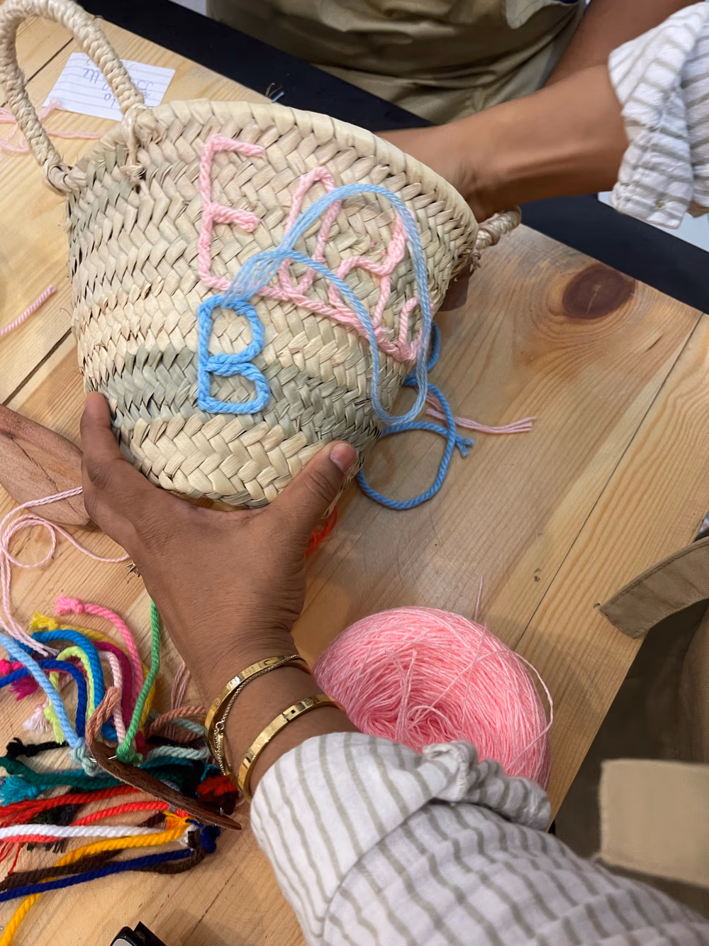 Participants sitting around a table during an embroidery workshop at Original Marrakech, working on their personalized baskets.