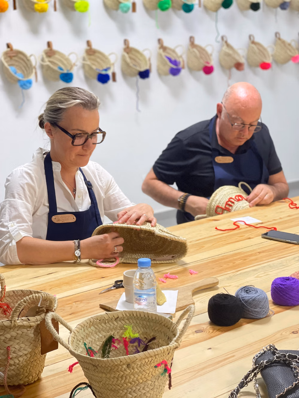 Participants at an embroidery workshop at Original Marrakech, surrounded by colorful thread spools.